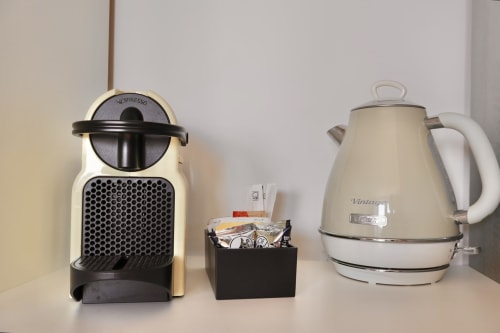 Macchina da caffè, bollitore e capsule di caffè sul bancone della camera a Taga Rooms hotel a Catania
