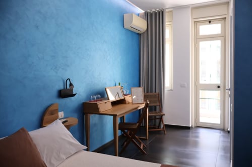 Camera deluxe Taga Rooms Catania con pareti blu, scrivania in legno, letto, aria condizionata e balcone con vista città