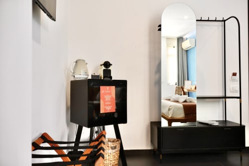 Camera da letto moderna con zona di lavoro presso Taga Rooms Catania: scrivania nera, specchio rotondo, bollitore e vista sul letto