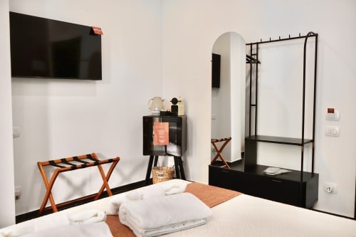 Camera Deluxe 401 Taga Rooms Catania: camera moderna con letto bianco, TV a parete, arredi neri e design accessibile