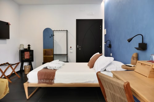 Camera Deluxe 401 Taga Rooms Catania - moderna camera da letto con letto in legno, biancheria bianca, parete blu e design contemporaneo