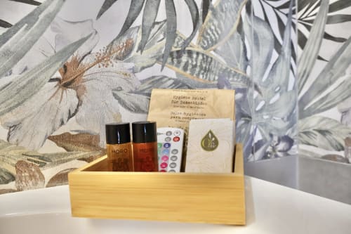 Cestino in legno con articoli da toilette e benvenuto presso l'hotel boutique Taga Rooms a Catania, Italia