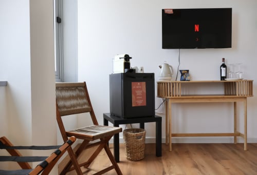 Camera moderna Taga Rooms a Catania con scrivania in legno, TV a schermo piatto, macchina del caffè e arredi contemporanei