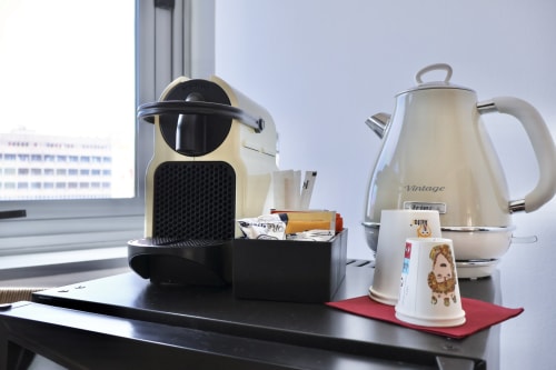Caffettiera e bollitore vintage sulla scrivania di Taga Rooms, hotel a Catania con vista sulla città dalla finestra
