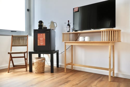Camera moderna presso Taga Rooms Catania con scrivania in legno, TV a schermo piatto, sedute confortevoli e vista sulla città