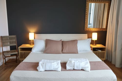 Camera moderna presso Taga Rooms Catania con letto matrimoniale, lampade da comodino, cuscini decorativi e specchio con vista sulla città