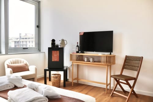 Camera moderna presso Taga Rooms Catania con TV, scrivania in legno, comodi posti a sedere e vista sulla città dalla finestra