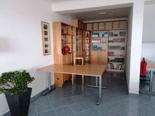 Espaço de trabalho moderno em apartamento com prateleiras em madeira, mesa de refeições e planta em vaso na A Casa da Xã, Ilha de Santa Maria