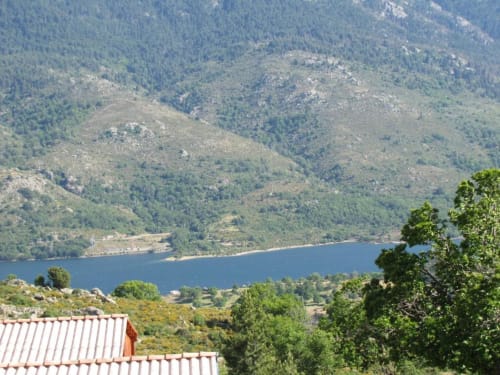 Vue pittoresque du lac de montagne avec collines boisées surplombant Les Chalets de Lozzi à Calacuccia