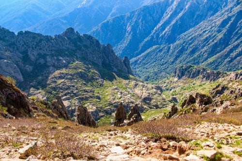 Paysage de vallée montagne avec terrain rocheux et pentes verdoyantes près de Calacuccia, Corse