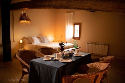 Acogedora habitación de Casa Tapiolas B&B en Molló, Girona, con zona de comedor e iluminación cálida