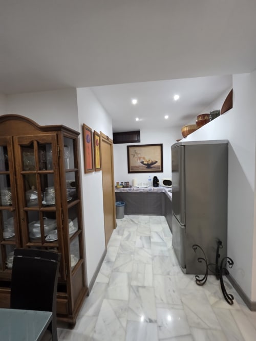 Cocina moderna del Hostal El Pasaje en Puente Genil con pisos de mármol, electrodomésticos de acero inoxidable y mueblería de madera