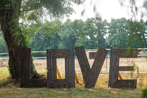 Rustic LOVE sign at Domaine De Bafave near a tree overlooking the countryside in Périssac, France
