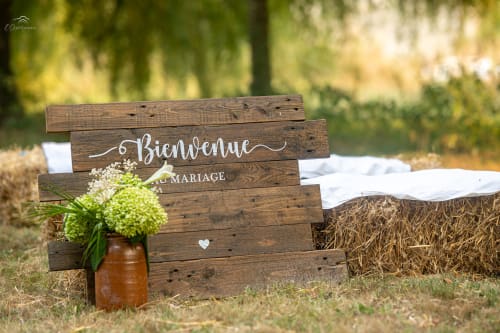 Rustic wooden welcome sign for a French wedding at Domaine De Bafave, decorated with white flowers in a vase