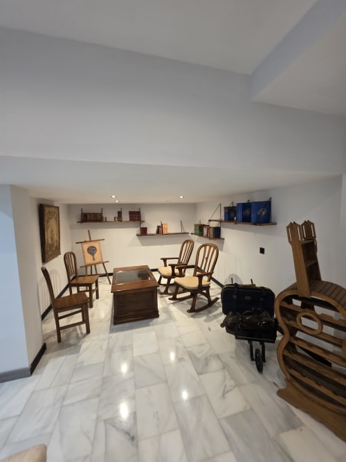 Lounge del Hostal El Pasaje con muebles de madera, pisos de mármol y estanterías en Puente Genil