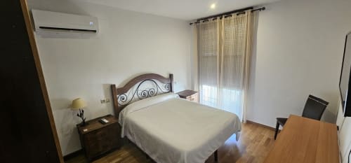 Habitación luminosa en Hostal El Pasaje, Puente Genil con cama doble, escritorio, aire acondicionado y acceso a balcón