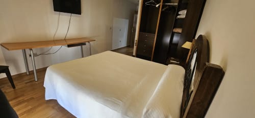 Double bed room at Hostal El Pasaje in Puente Genil with desk, TV, wardrobe and wooden flooring