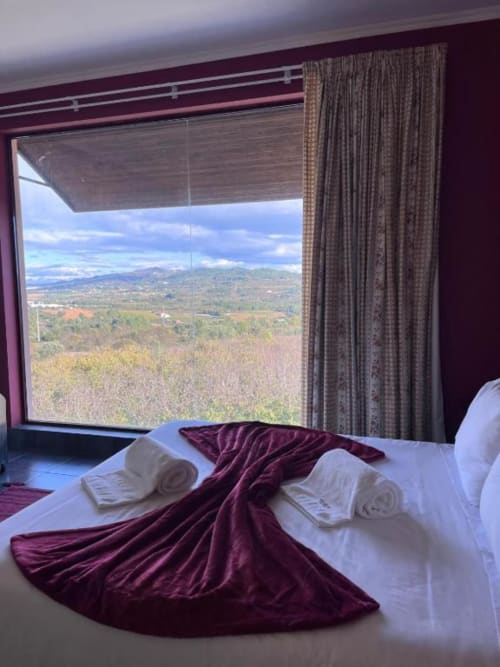 Quarto de luxo em Tranca da Barriga com vista panorâmica das montanhas de Covilhã, Portugal, grande janela com acabamento bordô