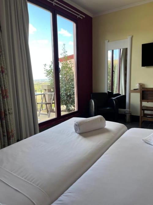 Quarto luminoso na Tranca da Barriga com camas de solteiro, vista para a montanha pela porta da varanda, comodidades modernas e aconchego