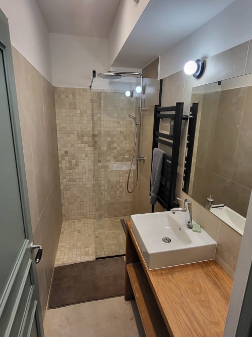 Salle de bain moderne au DOMAINE DES OISEAUX DE PASSAGE avec douche à l'italienne, vasque, sèche-serviettes chauffant et parquet.