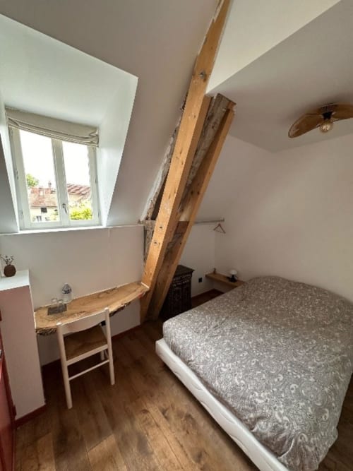 Chambre double accueillante au DOMAINE DES OISEAUX DE PASSAGE avec poutres apparentes, bureau, vue sur jardin et parquet