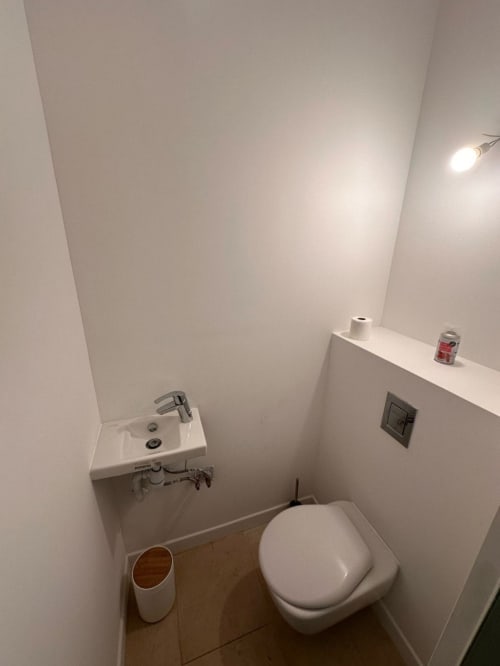 Salle de bain moderne et épurée au DOMAINE DES OISEAUX DE PASSAGE avec toilettes, lavabo compact et éclairage encastré
