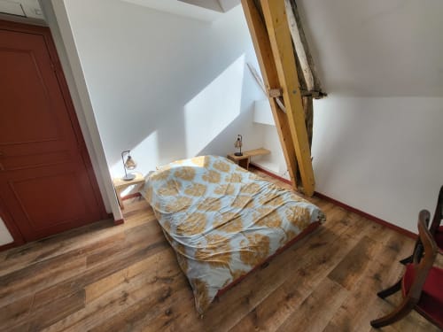 Chambre mansardée exotique au DOMAINE DES OISEAUX DE PASSAGE avec poutres en bois, literie patterned et verrière
