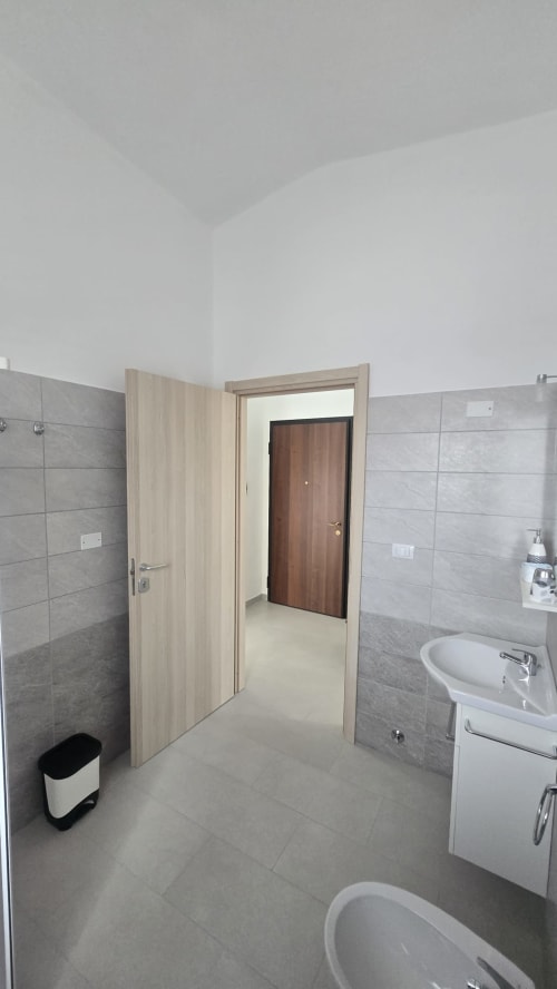 Moderno bagno dell'appartamento Casa Vacanze Maestrale presso Lux Immobiliare, Tronca, con lavabo, wc, bidet e piastrelle grigie