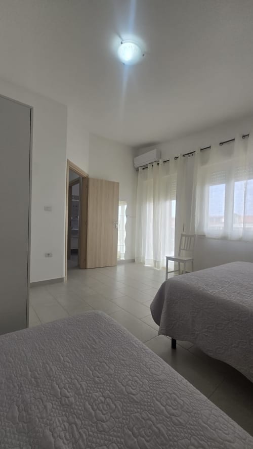 Camera moderna e luminosa a Casa Vacanze Maestrale a Tronca con letti gemelli, balcone con vista mare, aria condizionata e pavimento in piastrelle chiare