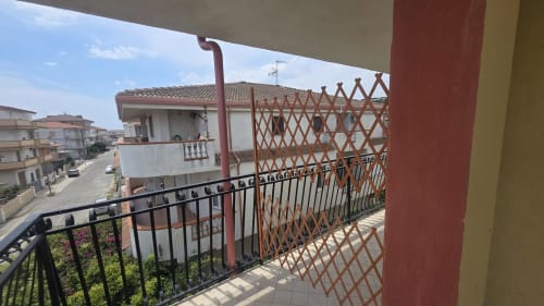 Vista dal balcone dell'appartamento fronte spiaggia di Tronca con schermo privacy a gelosia e edifici costieri