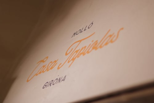 Rótulo manuscrito Casa Tapiolas en Molló, Girona, mostrando la elegante marca de esta casa rural