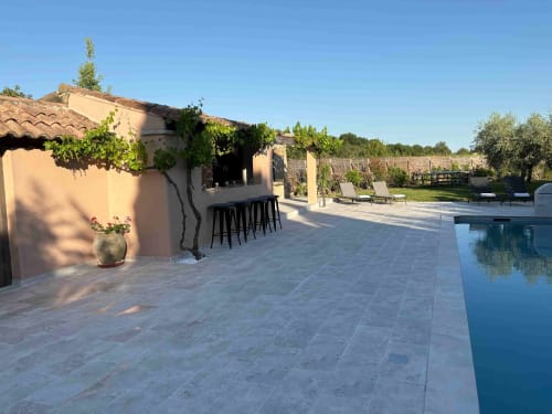 Magnanerie de Sainte Croix patio with pool, bar seating, and vineyard views in Saint Hippolyte de Caton