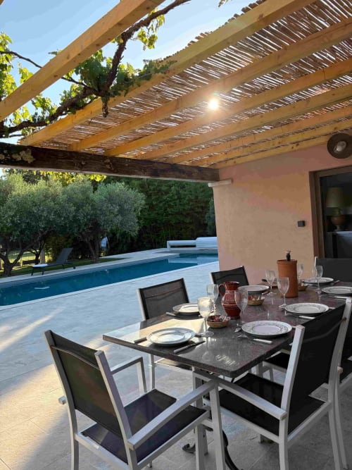 Outdoor dining patio with pool view at Magnanerie de Sainte Croix B&B in Saint Hippolyte de Caton, France