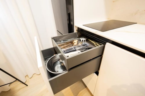 Cajón de cocina abierto mostrando utensilios culinarios en apartamento estándar de 2 dormitorios en Apartamentos La Búsqueda