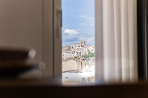 Vista desde el balcón del apartamento con panorámica de la histórica ciudad de Cuenca, su catedral y casas encaladas bajo cielo azul