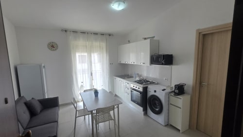 Cucina e zona pranzo moderna con elettrodomestici e accesso alla vista mare in Casa Vacanze a Tronca, Italia