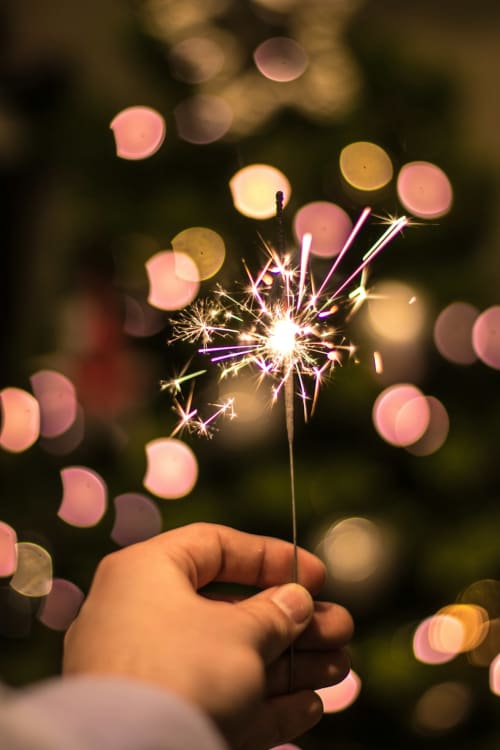Hand holding sparkler with soft pink bokeh lights at Domaine De Bafave, Périssac
