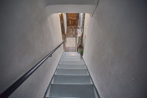 Escalera estrecha con paredes blancas y pasamanos negro en villa Casas Cercana en Abarán, España, que conduce al piso superior