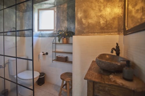 Baño moderno en villa Casa Cercana con lavabo de cobre, ducha con marco de vidrio, y azulejos blancos tipo metro