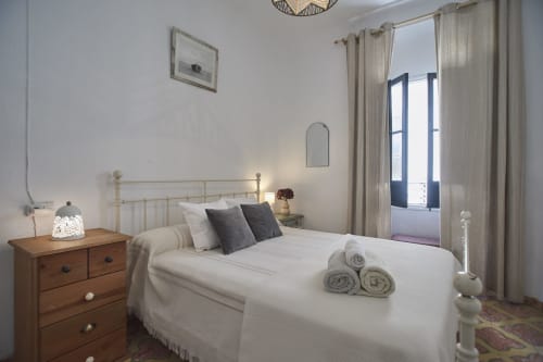 Habitación luminosa en la villa Casas Cercana de Abarán con ropa de cama blanca, cabecero metálico, mesita de noche de madera y puertas azules al patio