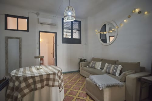 Acogedor salón de villa en Abarán con mesa de comedor, sofá beige, espejo redondo y lámpara colgante