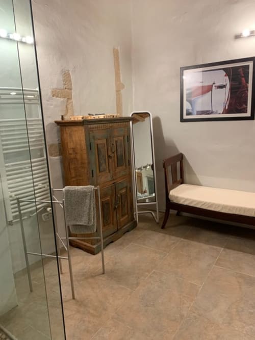 Salle de bains moderne à la Magnanerie de Sainte Croix avec mobilier en bois, porte-serviettes blanc et décor marin encadré