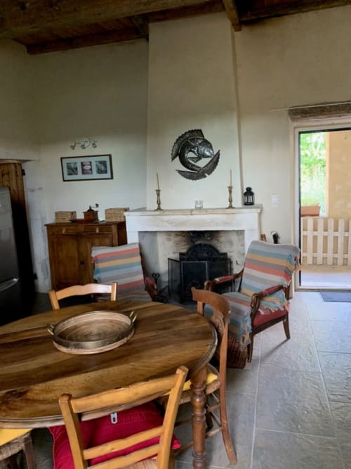 Séjour rustique avec cheminée, table à manger en bois et chaises rayées à la Magnanerie de Sainte Croix