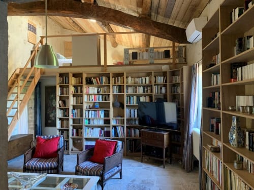 Spacieuse bibliothèque-salon pour 4 personnes à la Magnanerie de Sainte Croix avec étagères, mezzanine et accent rouge