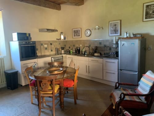 Spacieuse cuisine-salle à manger dans appartement 4 personnes à la Magnanerie de Sainte Croix avec table en bois, appareils modernes