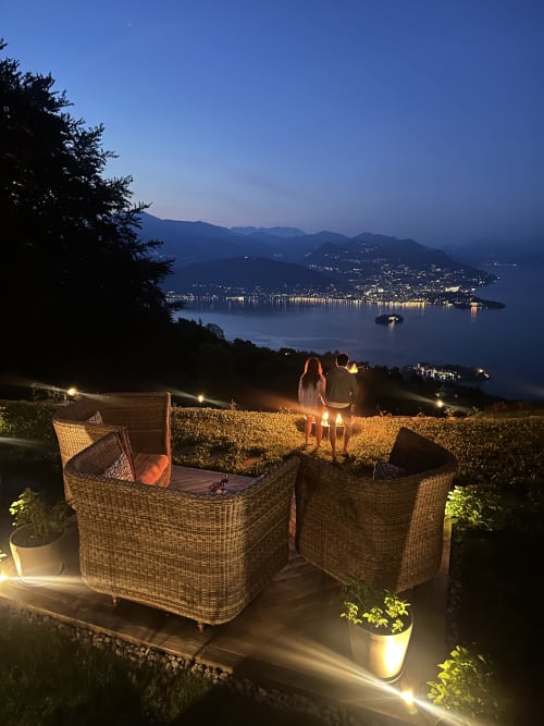 Coppia che ammira la vista serale del Lago Maggiore dalla terrazza di un lussuoso ritiro termale a Stresa