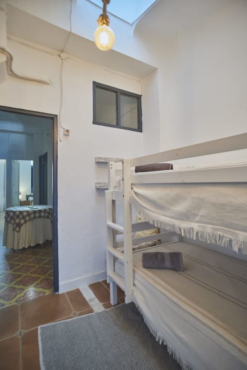Dormitorio luminoso con camas literas en villa Casas Cercana, Abarán, con tragaluz, estanterías y acceso a sala principal