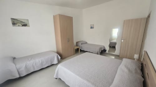 Ampia camera con più letti con vista mare all'appartamento Tramontana a Tronca, Italia