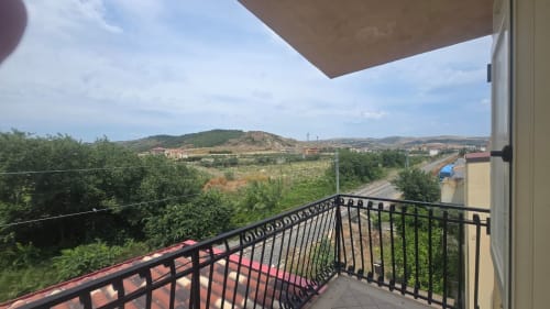 Vista dal balcone dell'appartamento vacanze Tramontana a Tronca con colline ondulate, paesaggio rurale e accesso diretto alla vista mare