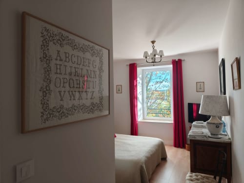 Chambre Perle de la Magnanerie de Sainte Croix avec rideaux rouges, vue sur le jardin et mobilier classique